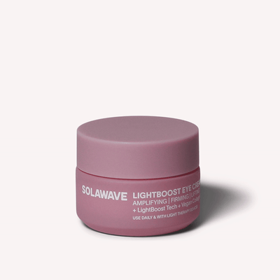Een roze Solawave LightBoost Eye Cream-potje is gecentreerd tegen een neutrale achtergrond, waarbij de LightBoost Tech en de Vegan Collagen-geïnfundeerde formule voor versterkende en verstevigende eigenschappen worden benadrukt om je huidverzorgingsroutine te verbeteren.